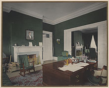a dark green room with a brown desk in the lower right corner