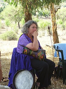 Photograph of Miriam Simos sitting in a chair outdoors