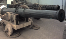 Two large metal cannon of differing designs, one in front of the other