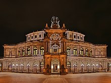 Barevná fotografie s nočním pohledem na průčelí historizující budovy Semperovy opery