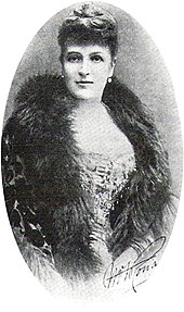 Photo of Ronalds from the waist up, facing the camera. She is handsome and well-dressed, with a fur collar and an "up" hairdo.