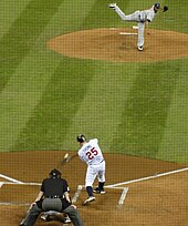 The moment of contact between Thome's bat and a pitch from Roberto Hernandez; the image is distorted through the black screen protecting those sitting behind home plate.
