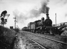 A steam train departing an old station