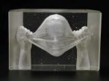 A glass sculpture in clear crystal with veiled face inside