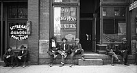 Men lounging outside saloon & Chinese laundry, Salt Lake City, 1910