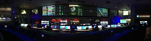 panaorama of the SFOF from the center of the room between the Cassini and Curiosity mission control consoles