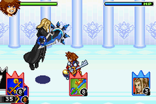 In the hallway of a palace, a spike-haired boy wearing red clothes and yellow shoes holds a large key, while a long-haired blonde man in black clothes holding a shield floats besides him. At the top of the image are two bars with the faces of the characters beside them. At the bottom of the image are three areas with cards shaped like rectangles with three spikes at the top, being respectively the decks of the player and the computer, and the card currently in use.