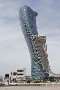 photo of a tall, glass, somewhat cylindrical building that starts out straight and leans to the left