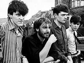 Joy Division в 1979 году. Слева направо: Стивен Моррис (ударные), Питер Хук (бас-гитара), Иэн Кёртис (вокал, ритм-гитара), Бернард Самнер (гитара, клавишные)