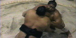 Aerial perspective painting of two sumo wrestlers inside a ring, pushing up against each other, locked in a wrestler’s hold.