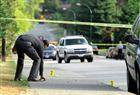 A police investigator examines the scene of an apparent shooting near the intersection of Jones Avenue and West 20th Street in North Vancouver Thursday. A 28-year-old North Vancouver man was wounded in the incident. He later died in hospital.