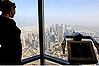 A woman looks over the city view at an observation point on the observation deck of the Burj Dubai tower, on Level 124 in Dubai.