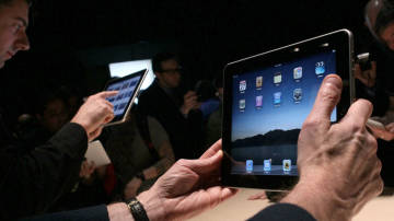 Event guests play with the new Apple iPad during an Apple Special Event at Yerba Buena Center for the Arts January 27, 2010. Apple announced Friday, March 5 the device release dates.