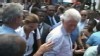 VIDEO: George Bush wipes his hand on Bill Clinton's shirt after greeting Haitians.