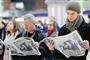 Commuters read about  the engagement of Prince William to Kate Middleton at Victoria rail  station in London.
