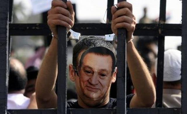 A protester wearing a mask of Hosni Mubarak stands inside a makeshift prison cell at Cairo's Tahrir Square. (File photo)