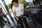 A woman attempts to fill her van with gasoline in this file photo.
