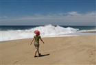 A visitor walks past thundering surf on the scenic beach of Todos Santos, Mexico.