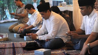 Indonesian men check their Blackberrys