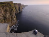 Photo: A couple on large rocky cliffs overlooking ocean