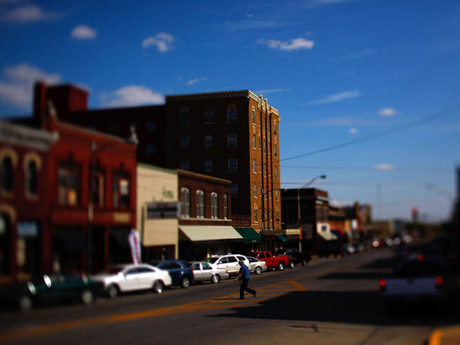 A pedestrian crosses the main street in downtown Chanute, Kan.