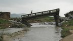 A man walks over a damaged bridge after heavy rain in Onchon County, North Korea