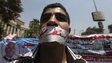 A protester has his mouth taped with a bandage and words reading in Arabic "Down with Shafik’ during a protest outside the Supreme Constitutional Court, 14 June 2012