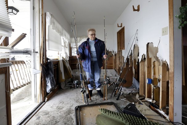 Carol Arnold removes fishing poles from her home in Cedar Bonnet Island, N.J., which was heavily damaged by the storm surge from Sandy. Frustration is setting in for some New Jersey residents who are still without power and running low on food. Some residents say too much attention is being paid to the Jersey Shore and not enough to working people who are hurting.