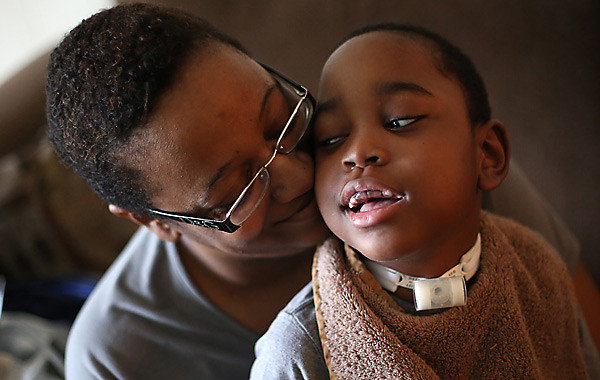 Octavia Byars holds son T.J. while he takes a break during physical therapy. Hundreds of Illinois parents whose medically fragile children receive skilled nursing services at home through a state-run program anxiously wait to find out if they will still qualify. (Heather Charles, Chicago Tribune)