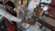 A man gauges liquefied petroleum gas in a cylinder at his makeshift shop in Karachi on April 22, 2010.
