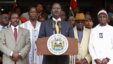 Kenya's Prime Minister Raila Odinga (C), flanked by members of the Coalition for Reforms and Democracy (CORD), addresses the media outside his office in Nairobi, March 16, 2013. 
