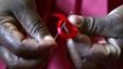 A Kenyan woman prepares ribbons ahead of World Aids Day at Beacon of Hope centre, a non-government organization formed to address women
