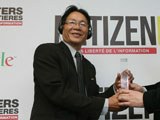 Huynh Ngoc Chenh (L) receives the Netizen of the Year award in Paris, March 12, 2013.