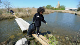 Volunteers pour into Fort McHenry wetlands to clean up