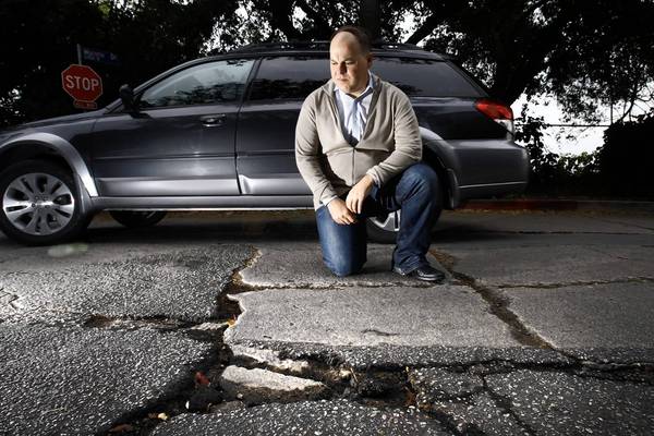 Gregory Leskin at Angus Street and Moreno Drive, near his Silver Lake home; he put in a request for repairs to the buckled and cracked pavement nearly three years ago, and is still waiting.