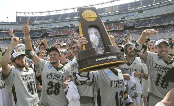 Loyola's Eric Lusby holds up the NCAA Division men's lacrosse championship trophy while celebrating with his Greyhounds teammates.