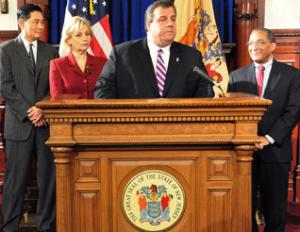 In this photograph released Monday, Jan. 23, 2012, by the office of New Jersey Gov. Chris Christie, the governor, center right, talks during a news conference that was attended by Phillip H. Kwon, left, Lt. Gov. Kim Guadagno, center left, and Bruce A. Harris in Trenton.