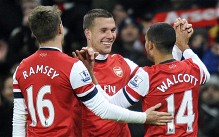 Arsenal's Theo Walcott (R) celebrates with teammates Aaron Ramsey (L) and Lukas Podolski (C) after scoring against West Ham