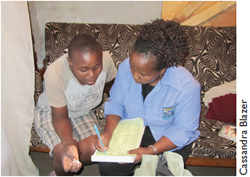 A counselor takes down the client's information before conducting an HIV test in the client's home