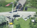The funeral procession of BSO Deputy Daniel Rivera drives under a U.S. Flag suspended between two fire trucks as it arrives at the Calvary Chapel. (Source: CBS4)
