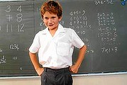 Portrait of a young boy in a school uniform smiling in class back to school - generic photo