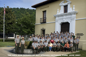 park employees, most in uniform, standing in front of adminstration building, on steps and around fountain