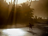 Photo: Surfer heading out of the water onto beach