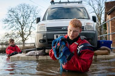 FLAG volunteers Aaron and Jay transport a trapped Environment Agency van over the flood waters on a floating pontoon