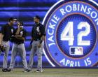 A Jackie Robinson banner hangs on the outfield wall of Rogers Centre, home of the Blue Jays as visiting White Sox pitcher Matt Thornton (l.) talks to Alex Rios (r.) during batting practice.