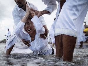 A Balinese woman cries while in a state of trance during Melasti Ceremony at a beach in Badung. The Melasti ritual is held annually ahead of the Nyepi Day of Silence, a ceremony intended to cleanse and purify the souls of the Balinese Hindu participants