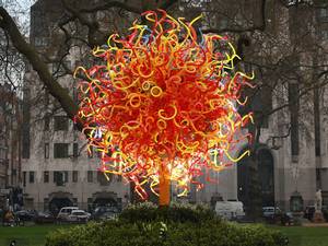 A new public sculpture by Dale Chihuly entitled the 'Sun' is illuminated in Berkeley Square in London