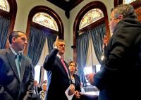 City Clerk Michael Geary, right, administers the oath of office to incoming City Manager Kevin J. Murphy, as Murphy&#8217;s son, Kevin T. Murphy, and the