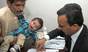Nine-month-old Muhammad Mosa Khan has his finger prints taken by an official in court
