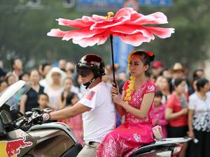 A woman arrives to take a part in a parade to celebrate the Dai ethnic group new year in Jinghong